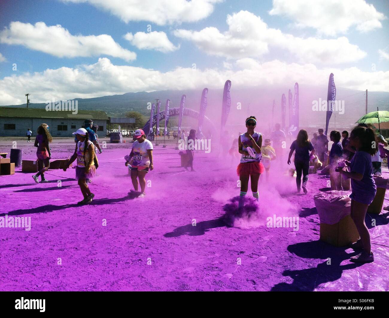 Les participants courent à travers la poudre violette à l'événement Color Run à Kailua-Kona, Big Island Hawaii - course amusante, festival, fitness et concept de style de vie - Image de stock capturée avec un smartphone