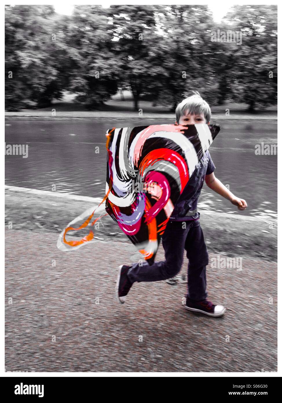 Boy running avec un cerf-volant. Banque D'Images