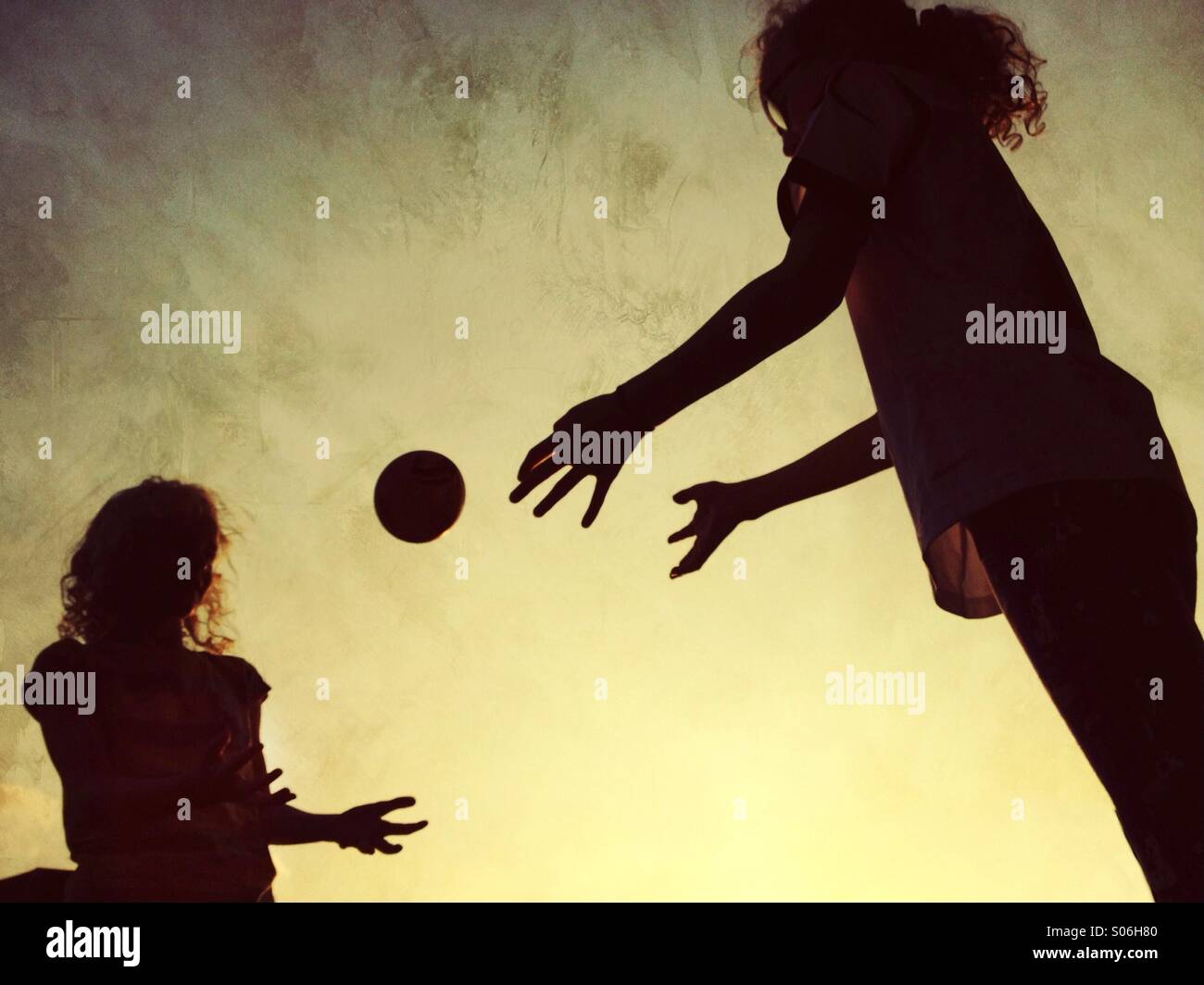 Deux jeunes filles en silhouette throwing ball entre eux - Image de stock capturée avec un smartphone