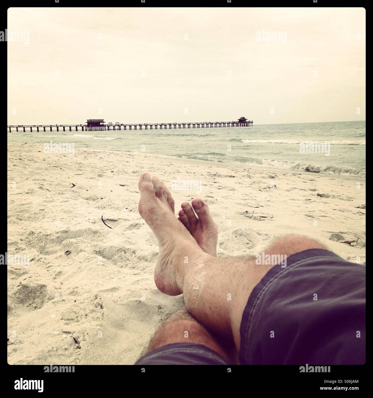 Personne qui porte sur la plage. Pieds dans le sable, à Naples, en Floride. Banque D'Images
