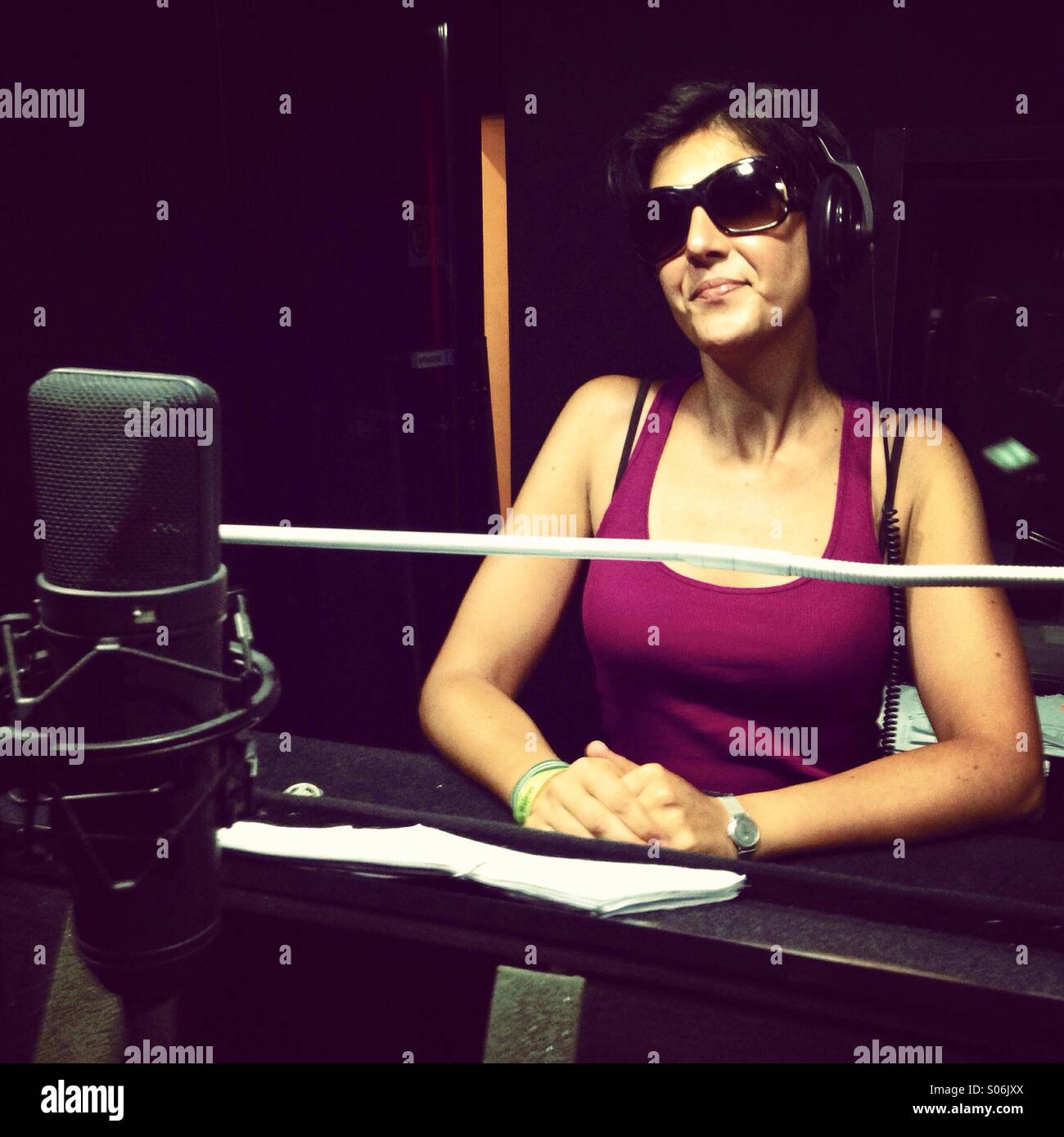 Belle femme portant des lunettes de soleil dans un studio d'enregistrement Banque D'Images