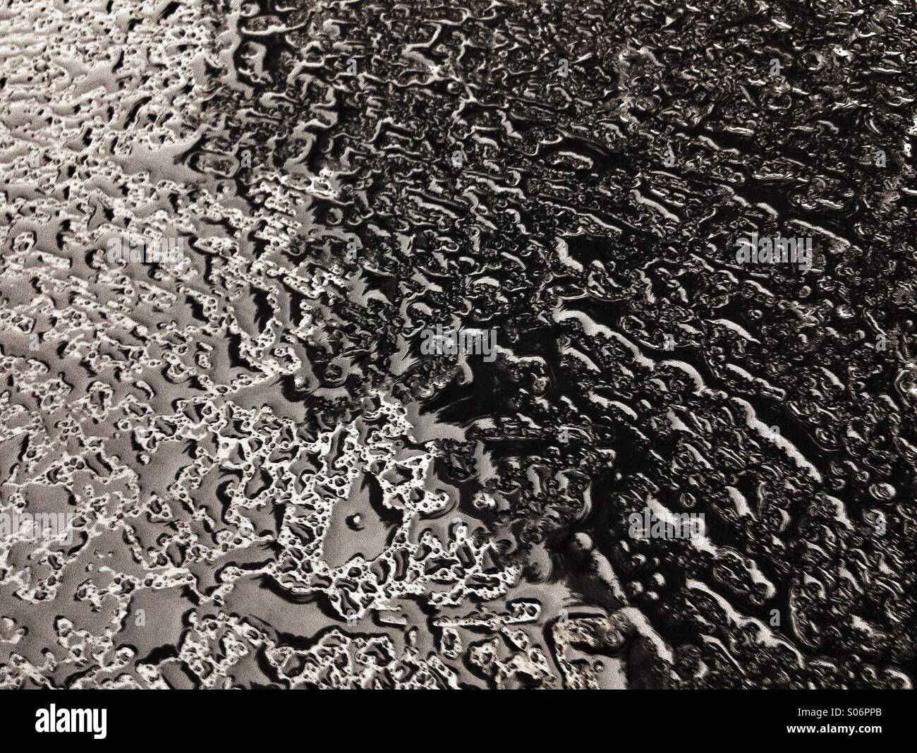 Les gouttelettes d'eau sur un tableau en émail noir brillant - Image de stock capturée avec un smartphone