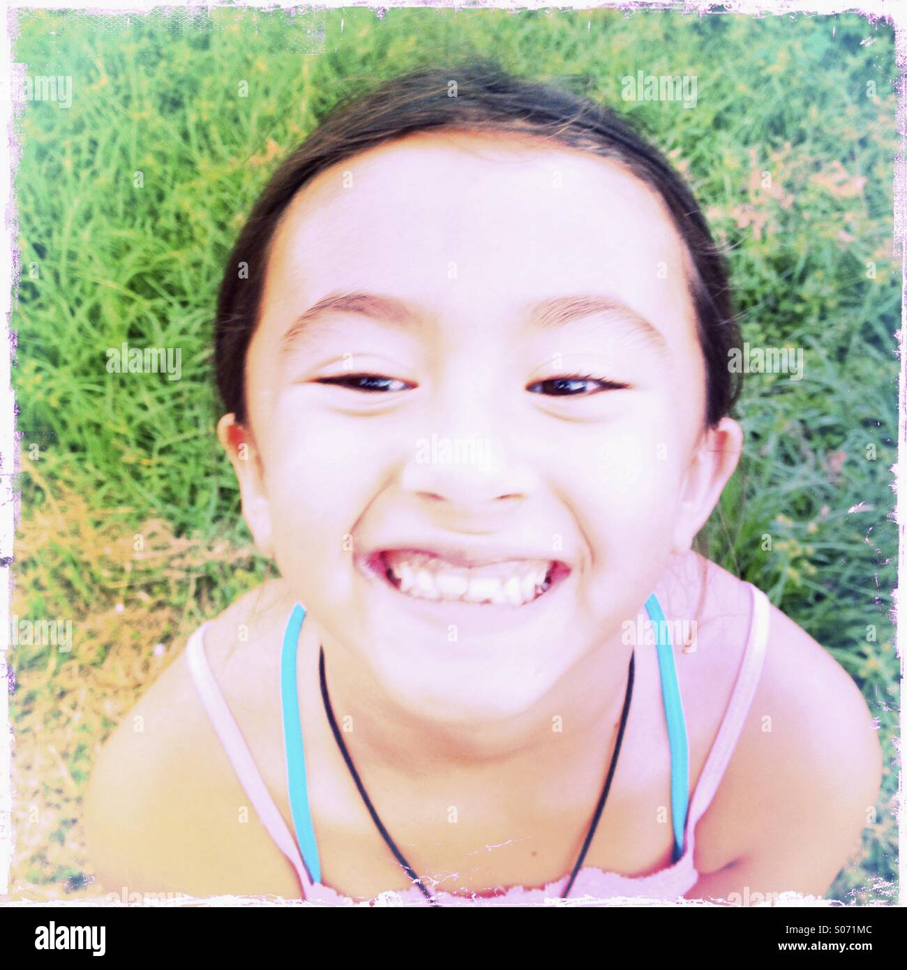 Close up portrait of a grinning sept ans Asian American girl. Banque D'Images