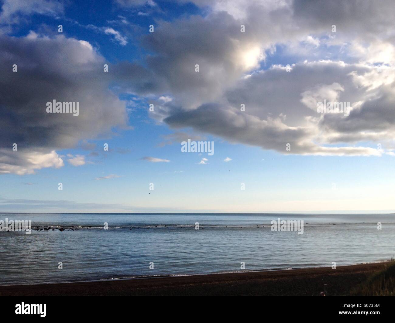 La ligne de côte et ciel nuageux Banque D'Images