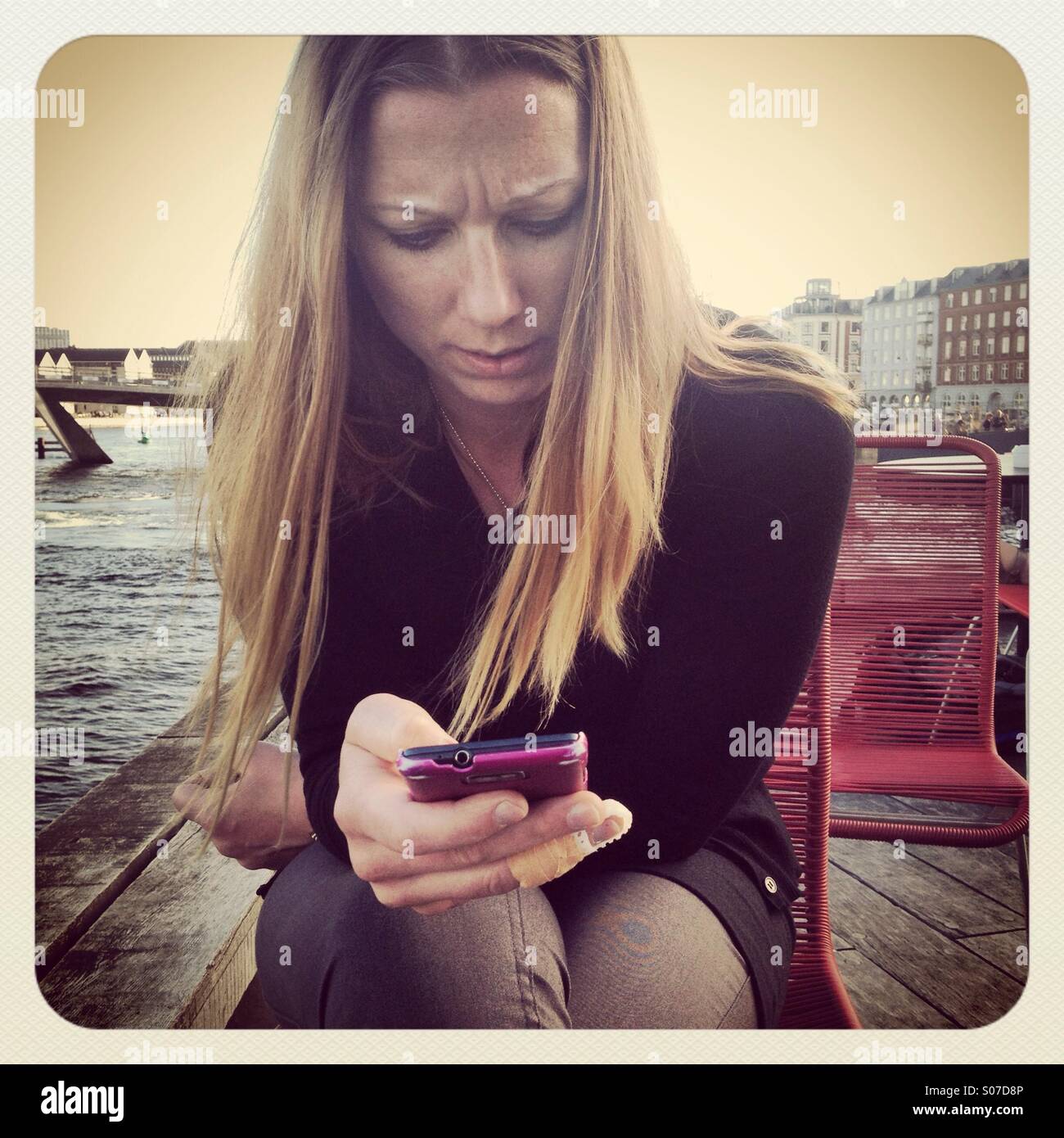 Une femme scandinave nordique à confus à son téléphone mobile au milieu de Copenhague Banque D'Images