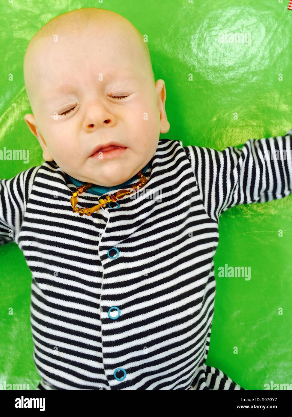 Un bébé de 3mois garçon portant un amber teething necklace l'éternuement Banque D'Images