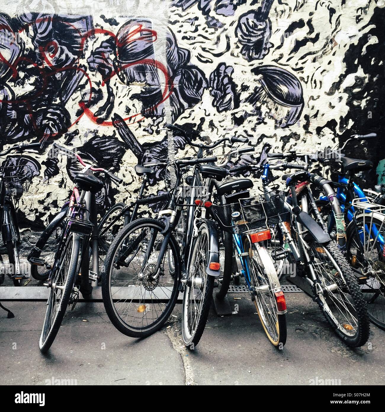 Bicyclettes garées en face de mur avec l'art de la rue, Hackesche Hofe, Mitte, Berlin, Allemagne Banque D'Images