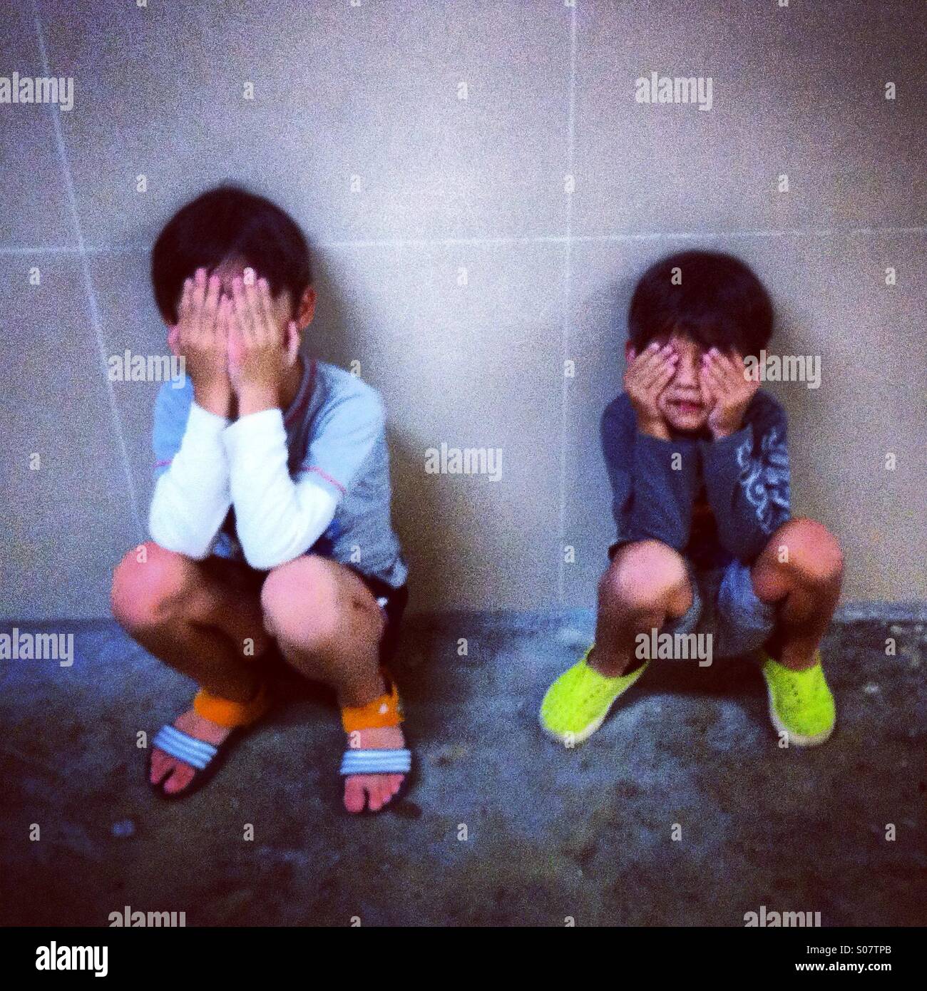 Deux enfants cache leurs visages Banque D'Images