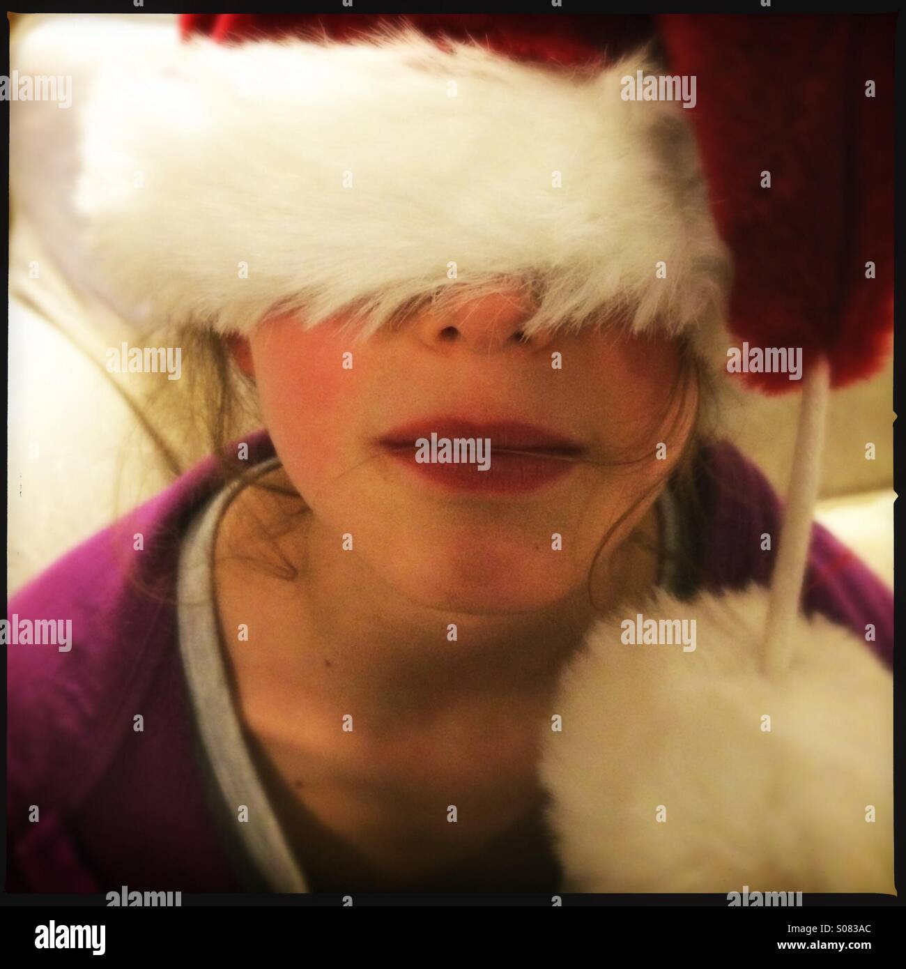 Girl with Christmas hat tiré sur ses yeux Banque D'Images