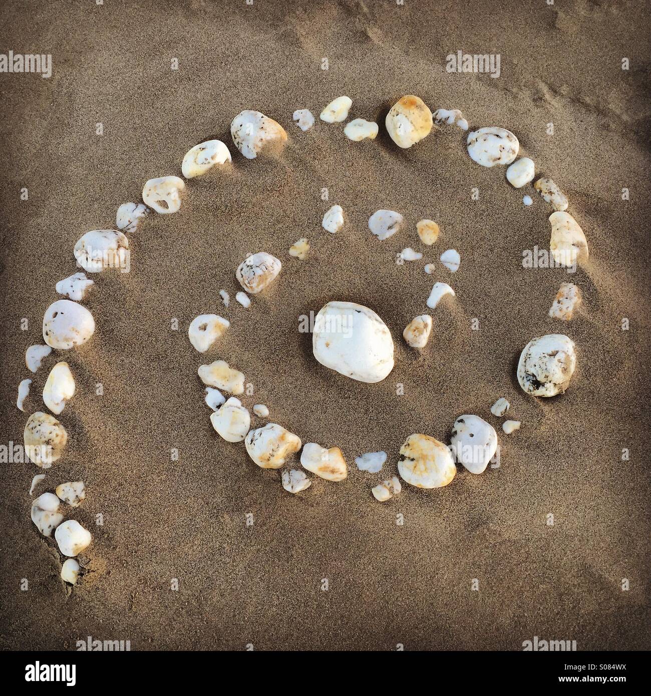 Beach art, spirale de galets sur la plage de sable - Image de stock capturée avec un smartphone