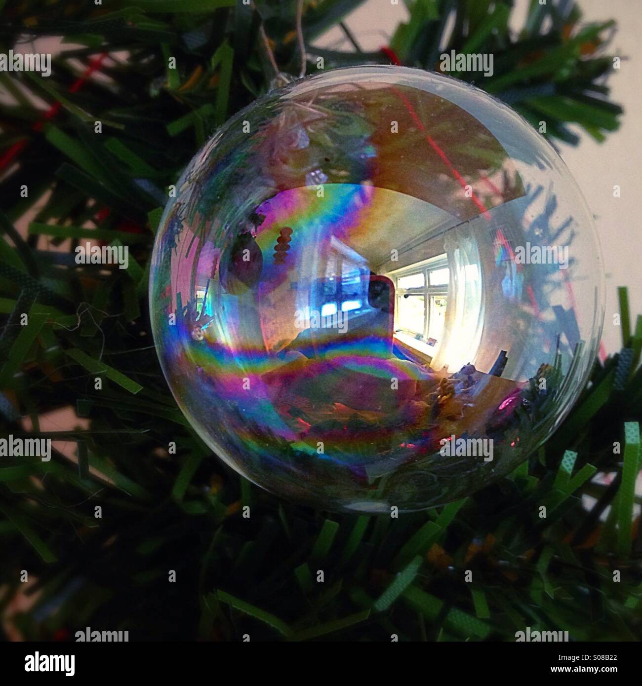 Reflet d'une fenêtre dans une boule de cristal suspendu à un arbre de Noël Banque D'Images
