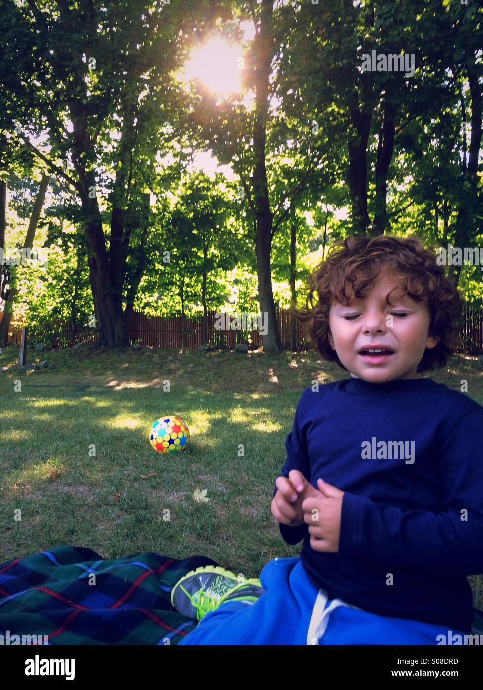 Un jeune garçon avec des allergies saisonnières les éternuements en plein air dans un parc dans le Connecticut, USA. Banque D'Images