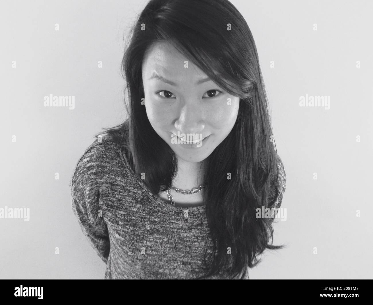 Portrait noir et blanc d'une belle jeune femme asiatique à la recherche jusqu'à l'appareil photo ci-dessus. Banque D'Images