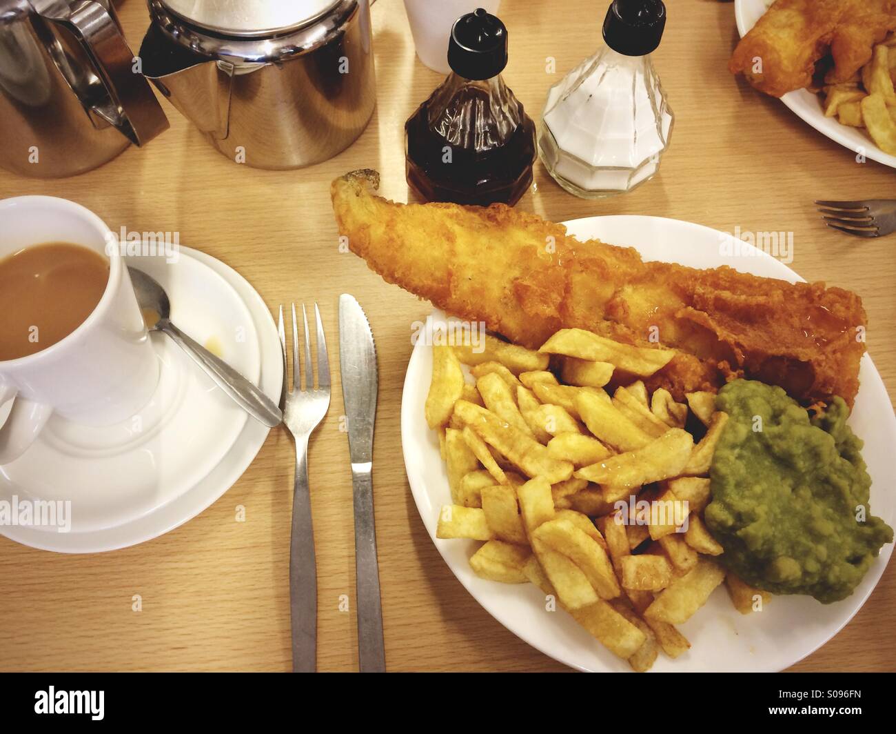 Un plat de poisson et frites avec petits pois dans un dans le Northumberland, chippy UK. Banque D'Images