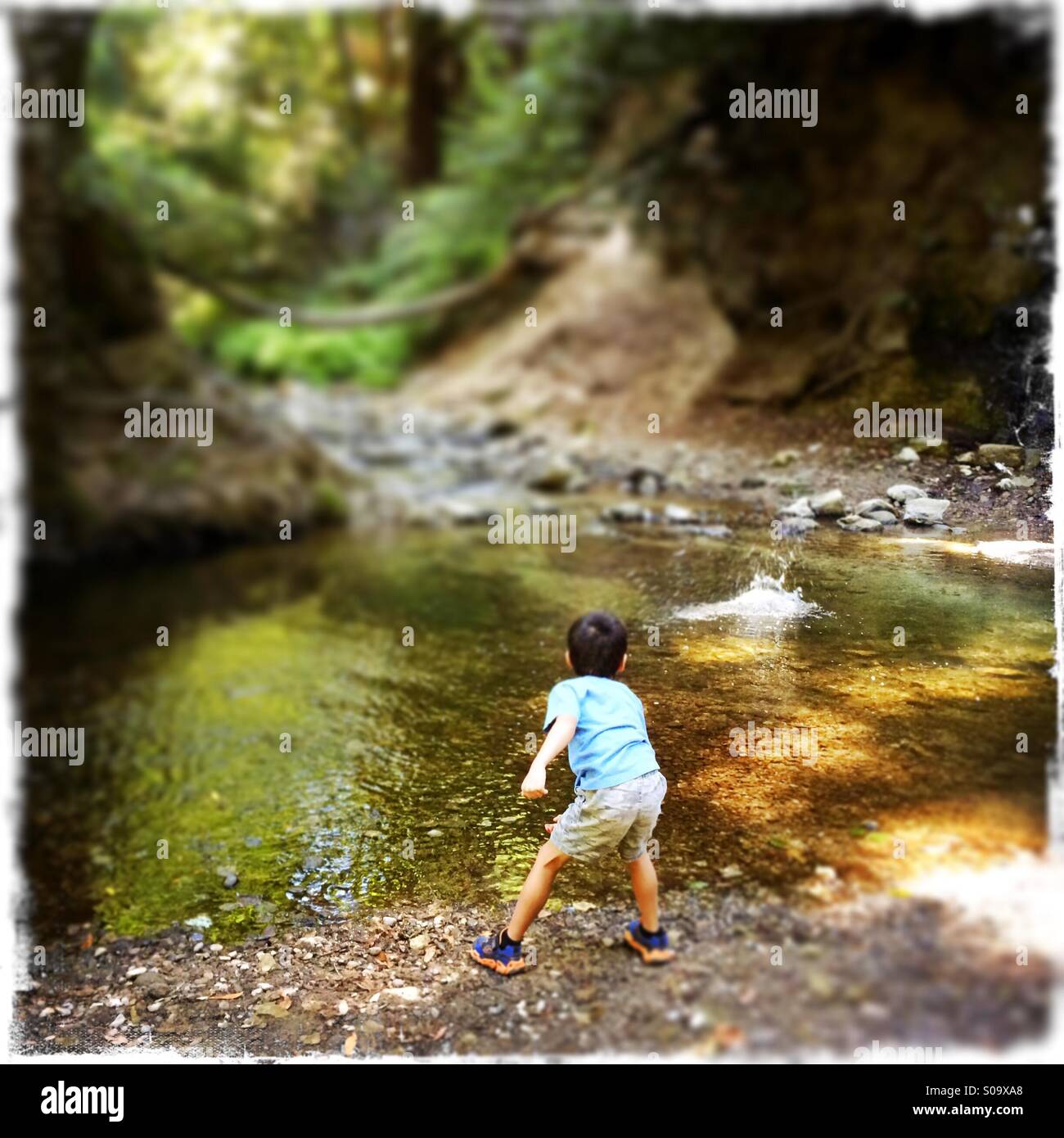 Un garçon de six ans saute sur les roches du ruisseau Bean. Le Comté de Santa Cruz, Californie, USA - Image de stock capturée avec un smartphone