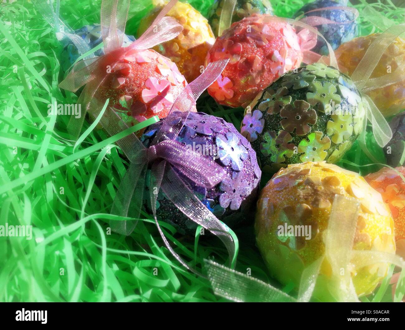 Les oeufs de Pâques colorés décorés dans un lit de gazon artificiel Banque D'Images