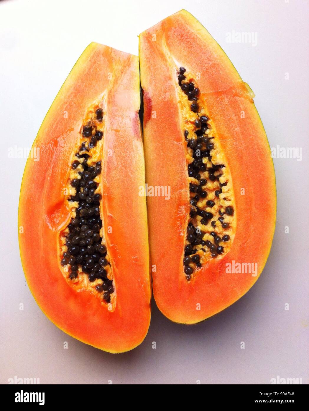 Les papayes mûres coupées en deux sur la longueur Banque D'Images