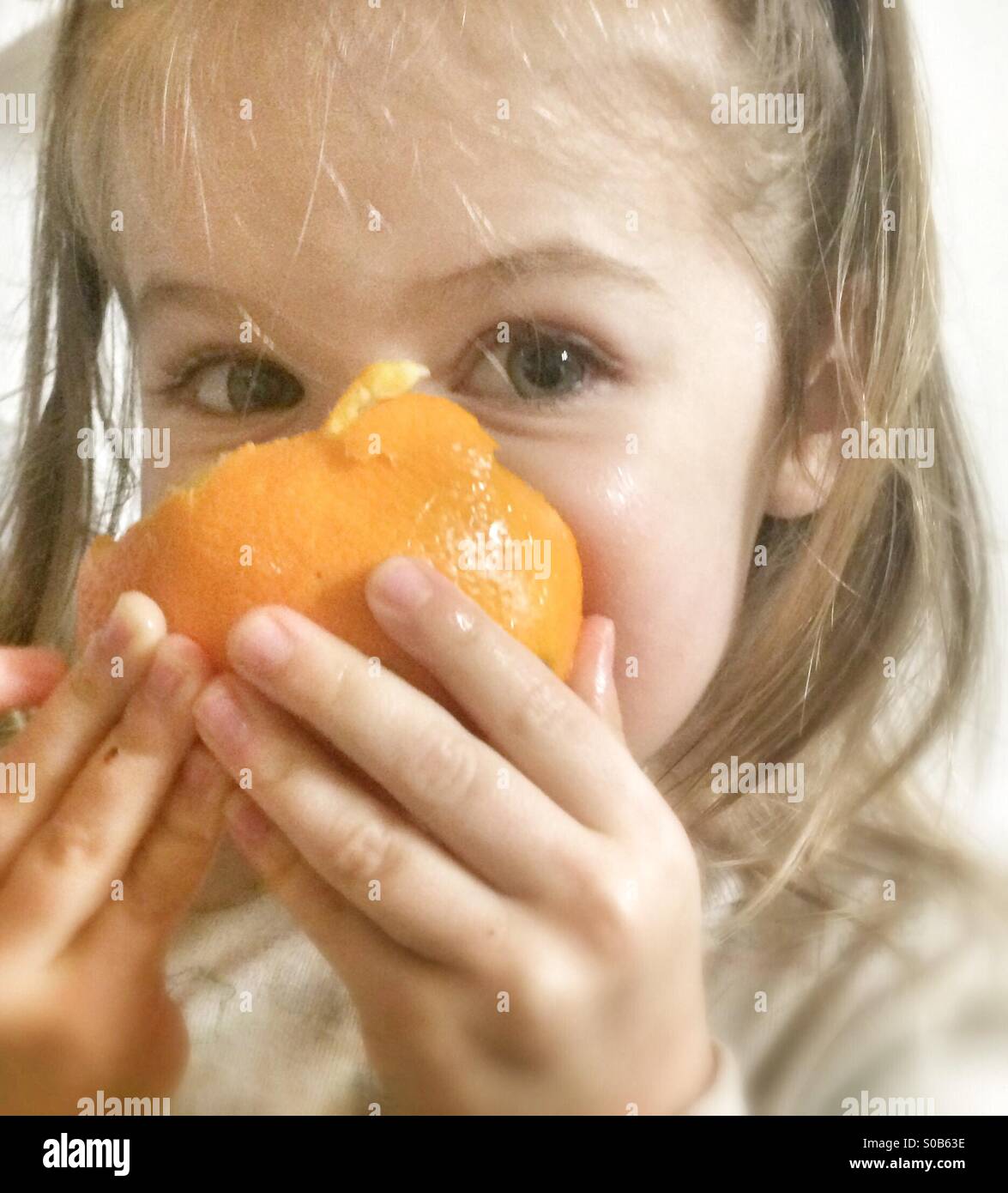 Tout-petit mange Orange Banque D'Images