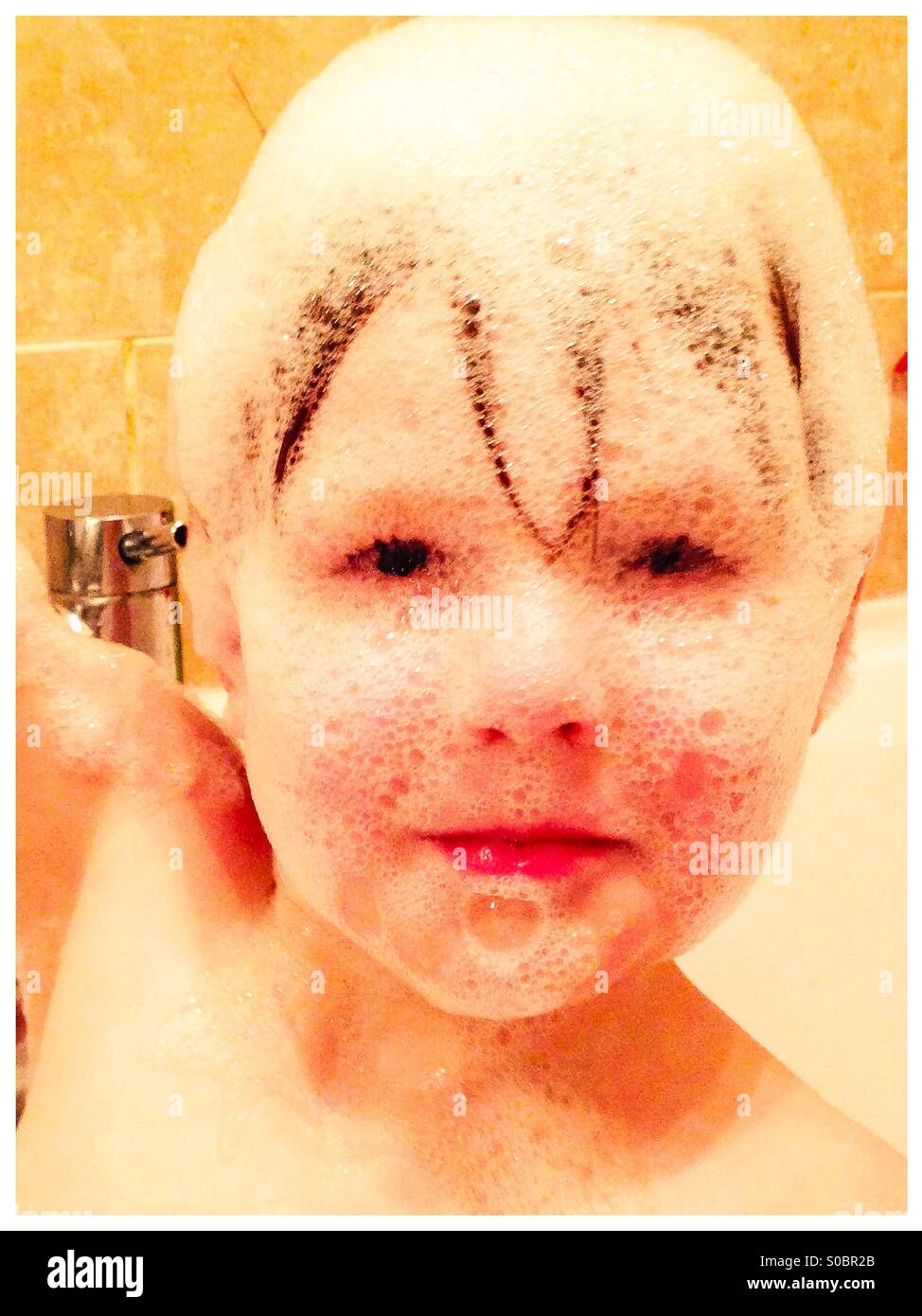 Garçon avec bain bulles sur son visage Banque D'Images