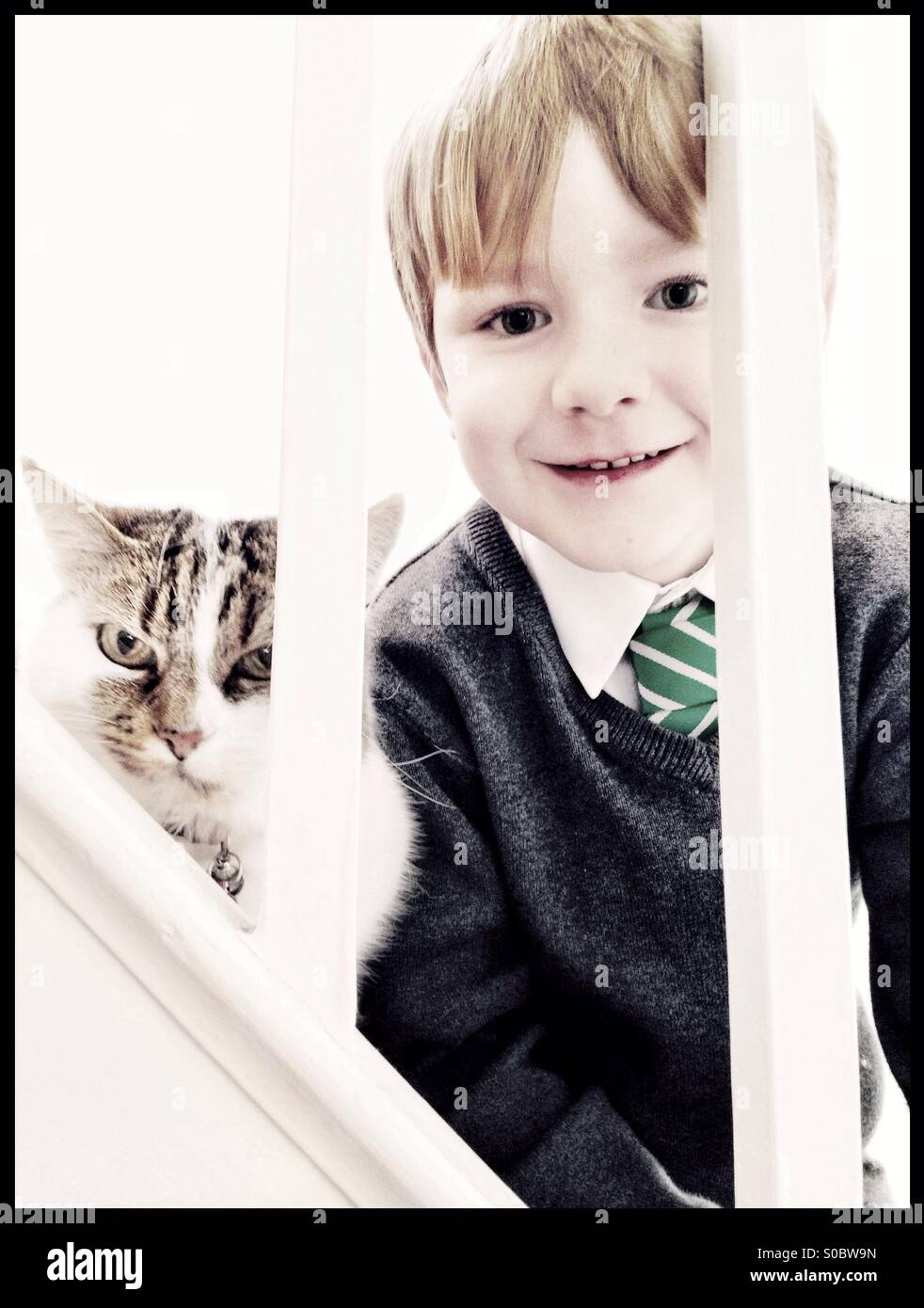 Écolier et son chat voyeur à travers la rampe. Banque D'Images