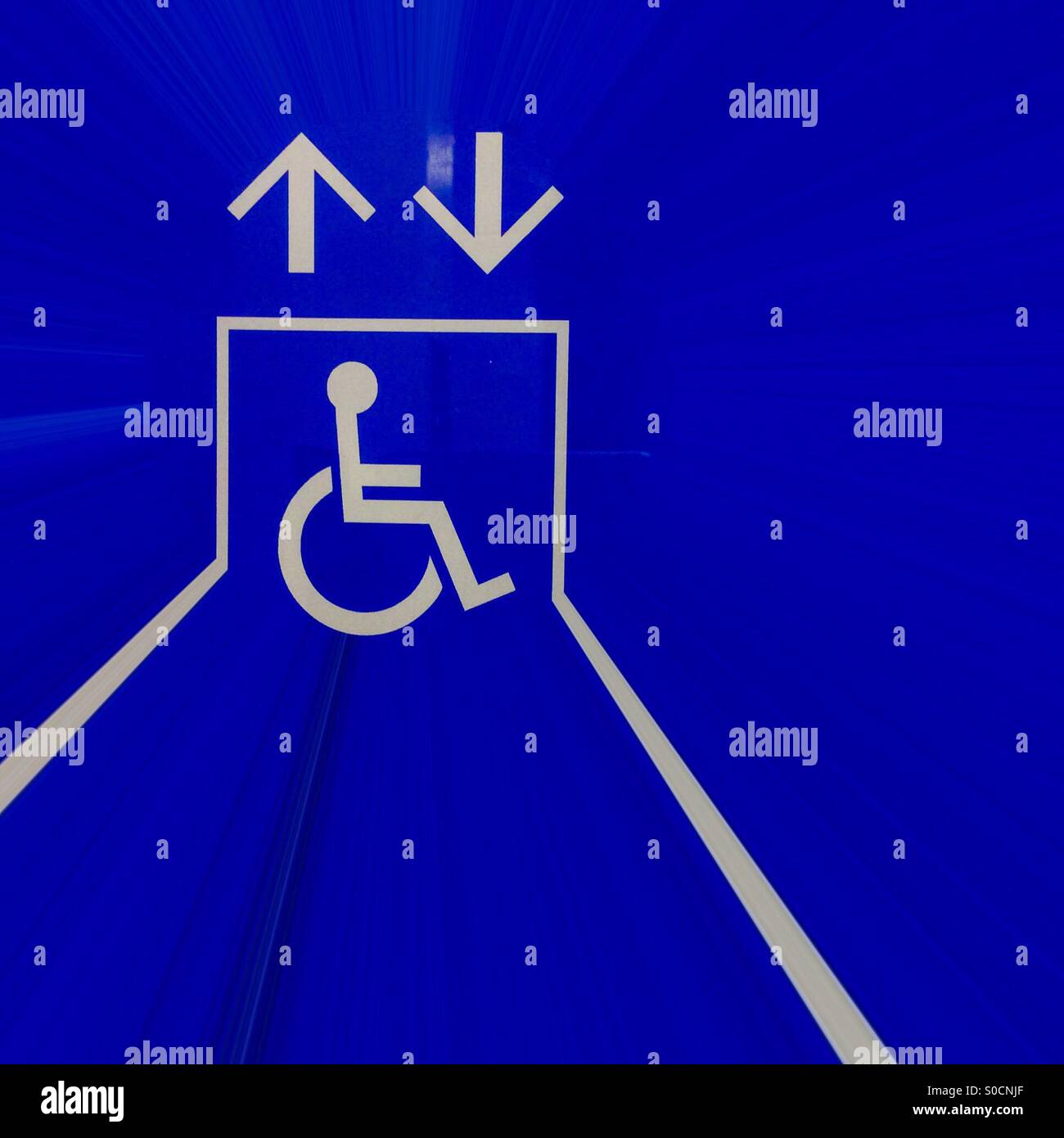 Haut bas. Un panneau d'accès pour fauteuil roulant élégant près d'un ascenseur, Ontario, Canada. Pictogramme. Pas de mots. Icône uniquement. Universel. Banque D'Images