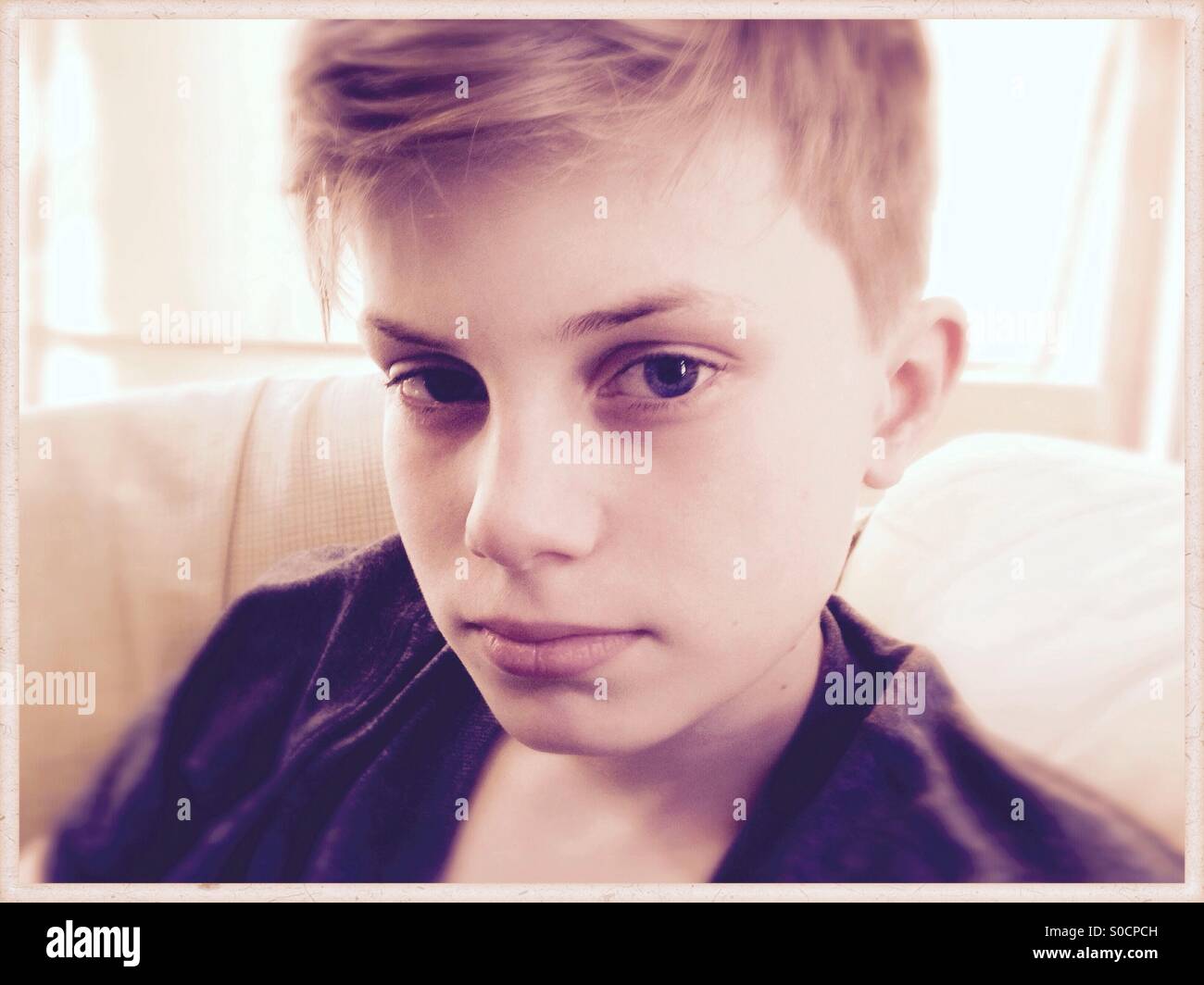 Portrait d'un jeune garçon avec regard sérieux. Banque D'Images
