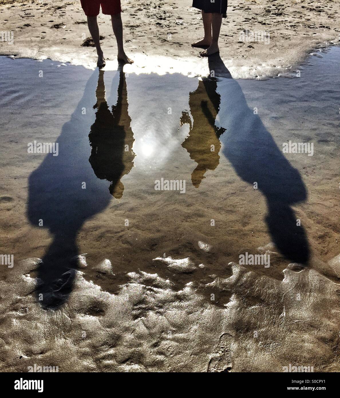 Réflexions et de grandes ombres sur la plage Banque D'Images