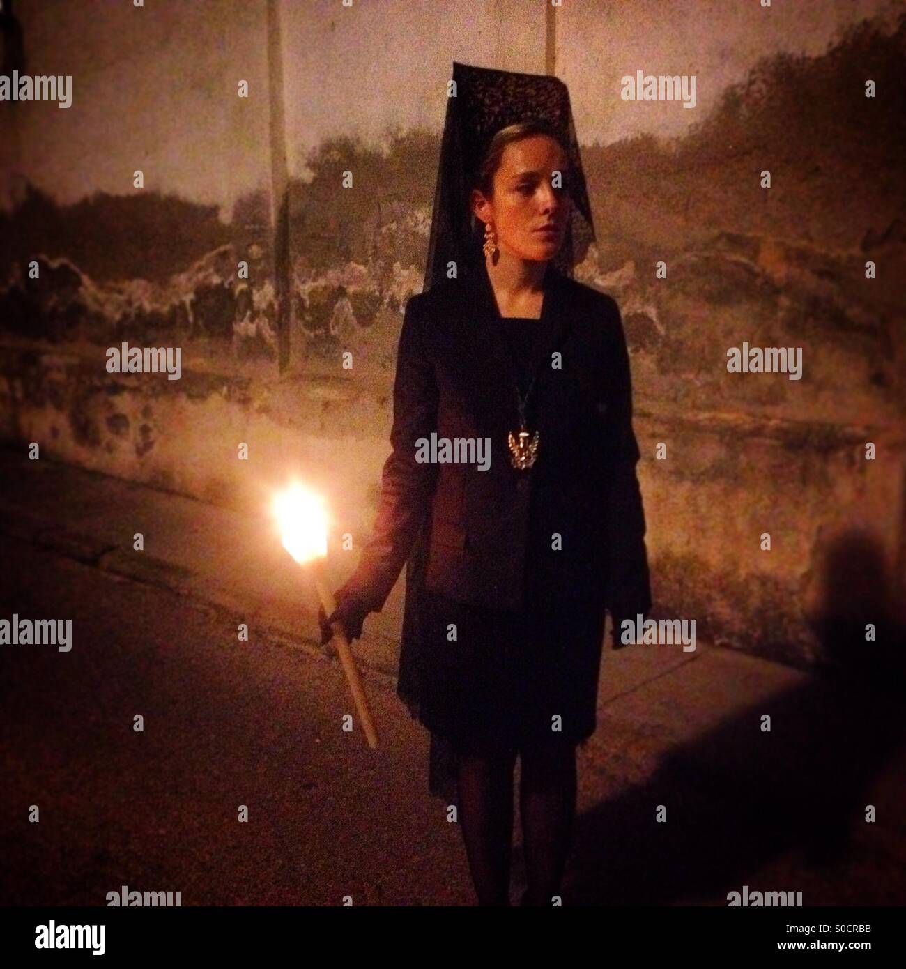 Une femme portant un mantilla et tenant une bougie lors d'une procession de la Semaine Sainte de Pâques à Trujillo, Cáceres, Extremadura, Espagne Banque D'Images