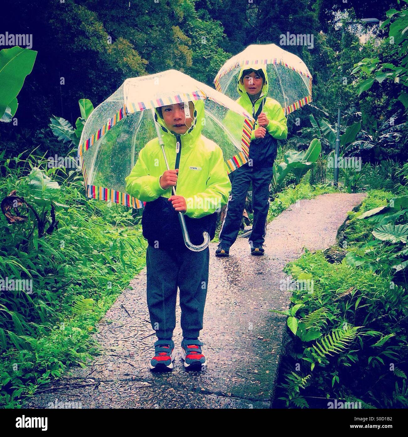 2 garçons avec umbrealla sous la pluie Banque D'Images