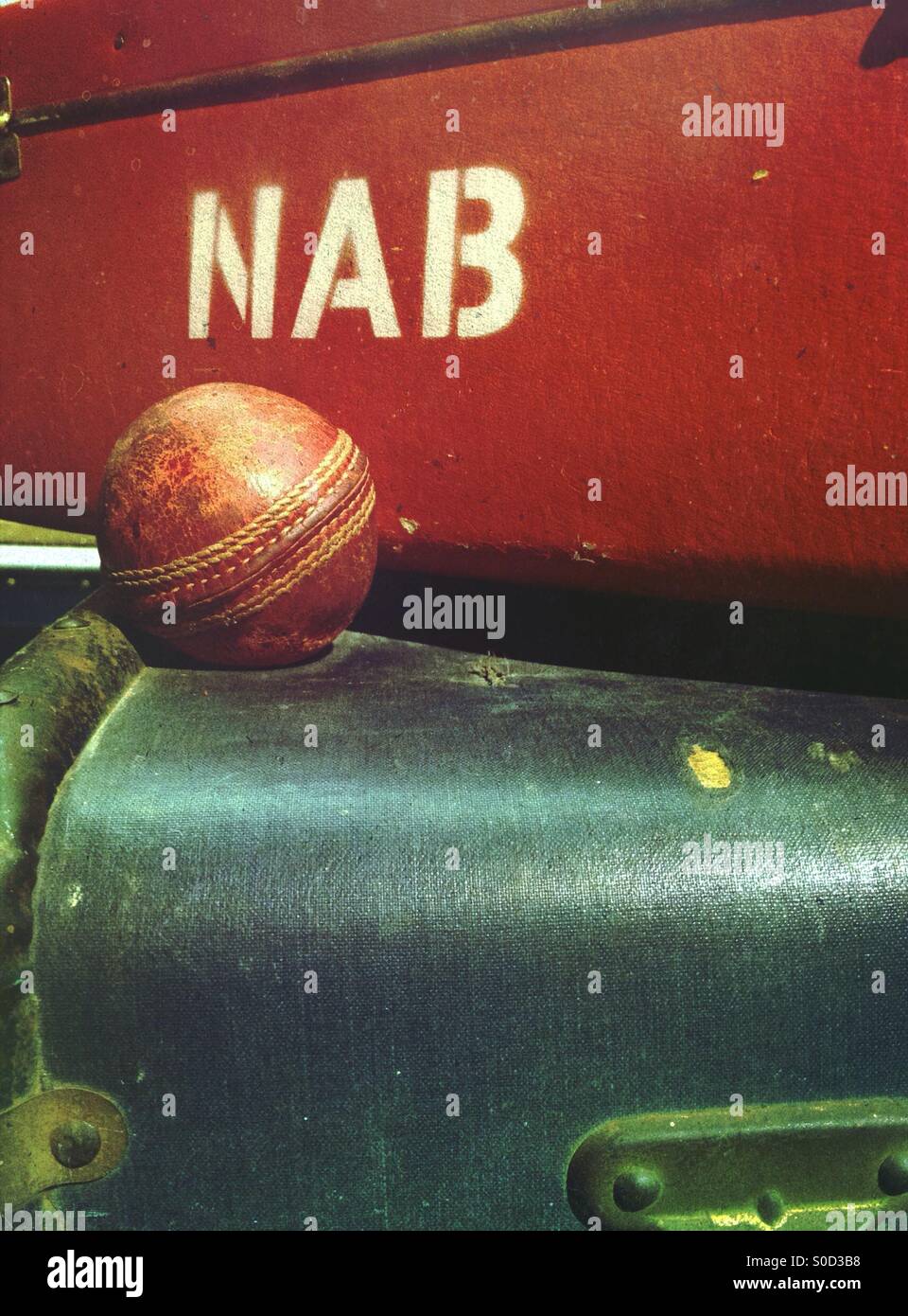 Close up of cricket ball sur une pile de valises Banque D'Images