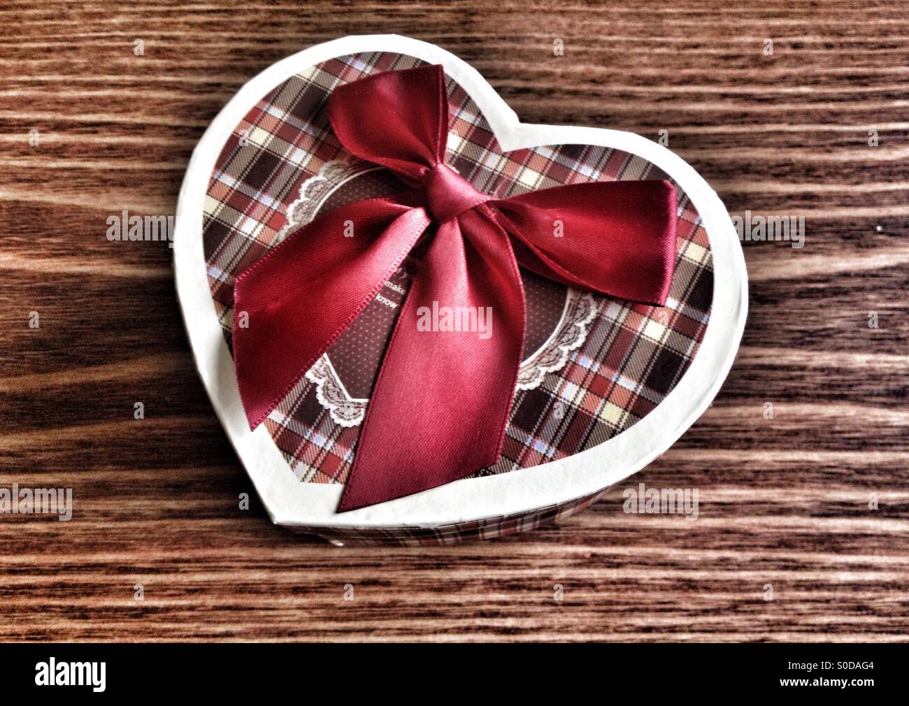 Boîte-cadeau avec forme de coeur sur une table en bois - Image de stock capturée avec un smartphone