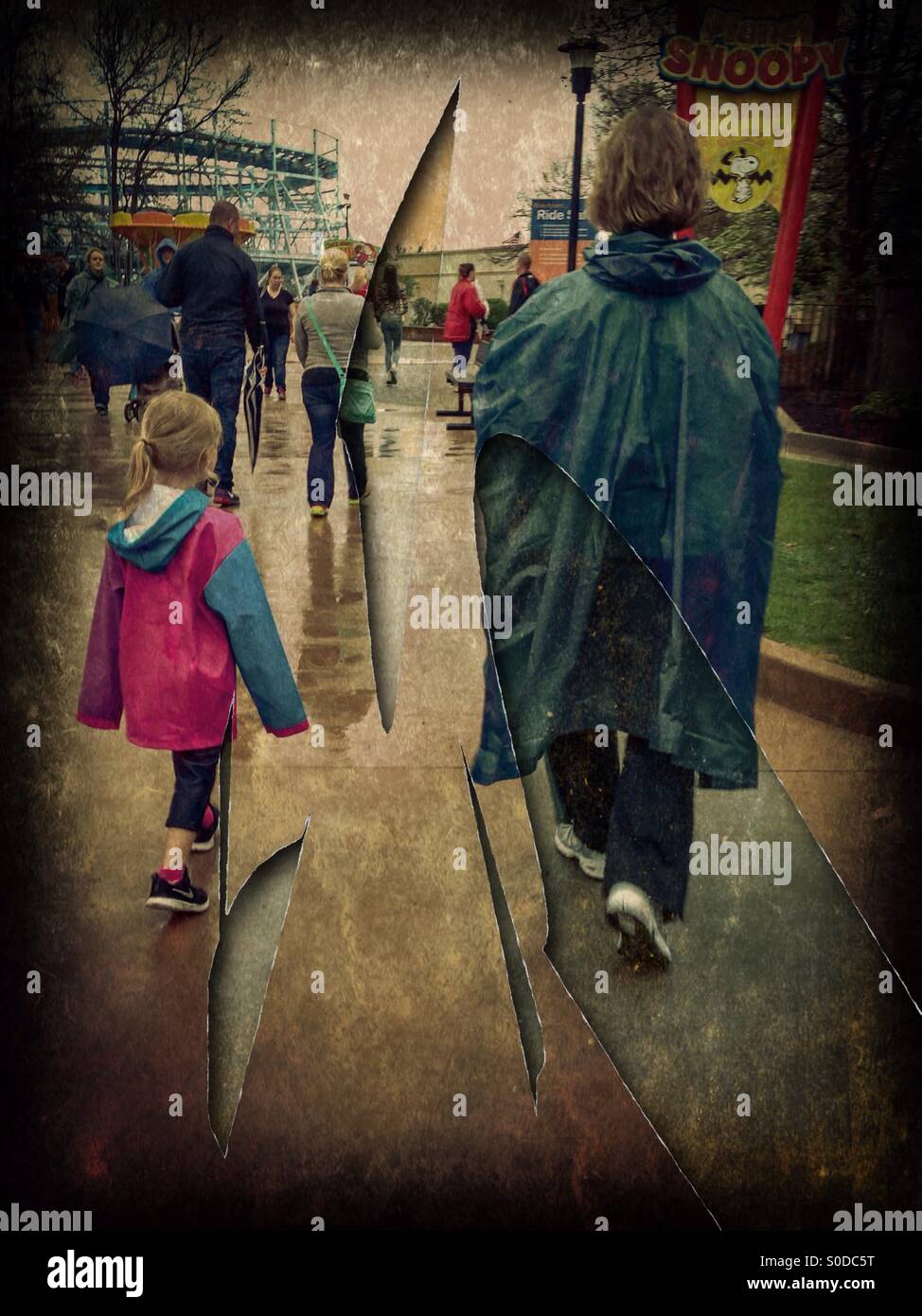 Une grand-mère et petite-fille d'un jour pluvieux à un parc d'amusement. Banque D'Images