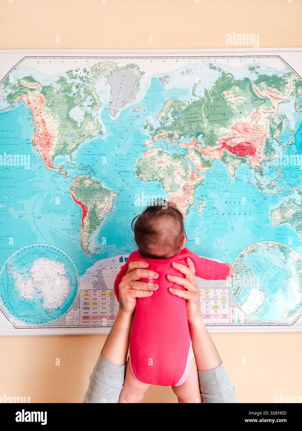 Hello World ! Père tenant son bébé fille jusqu'en face de la carte du monde Banque D'Images