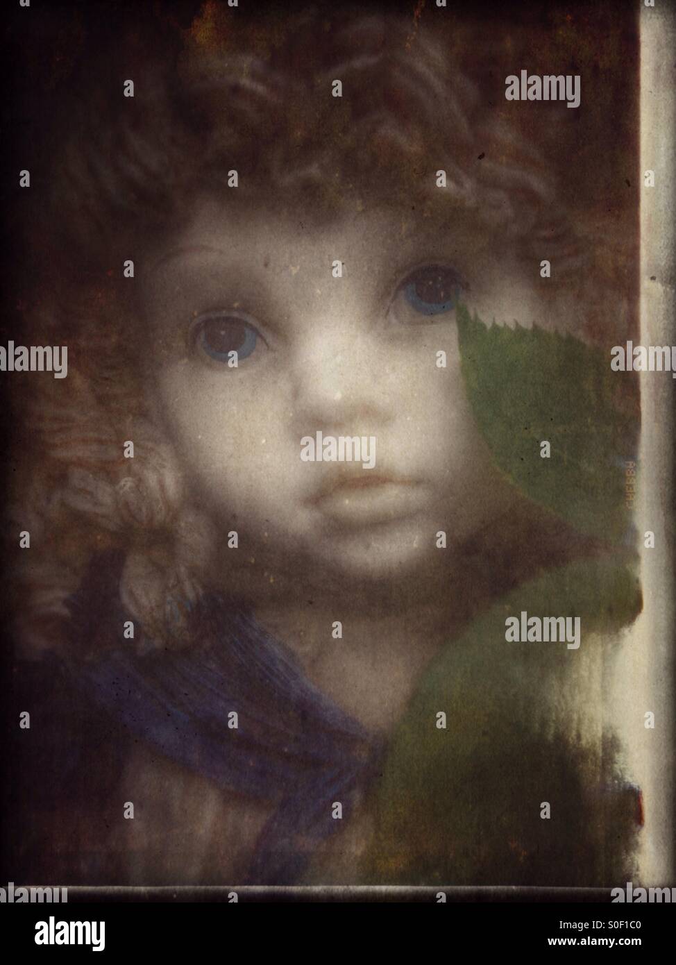 Les feuilles d'un buisson rose badigeonner la joue d'une statue d'une fille (1). Banque D'Images