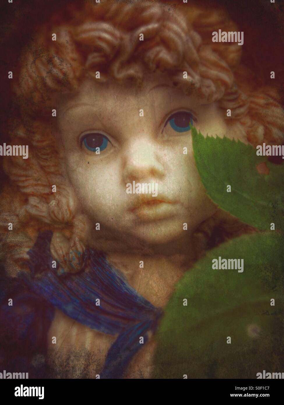 Les feuilles d'un buisson rose badigeonner la joue d'une statue d'une fille (2). Banque D'Images