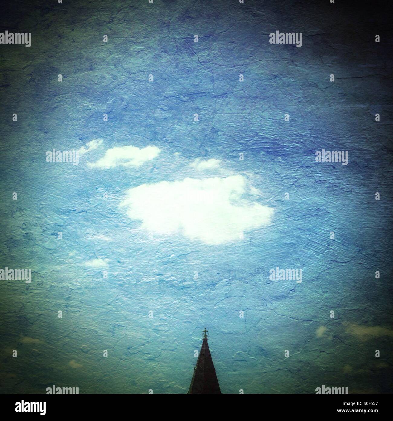 Un nuage blanc moelleux dans un ciel bleu au-dessus d'un clocher pointu - Image de stock capturée avec un smartphone