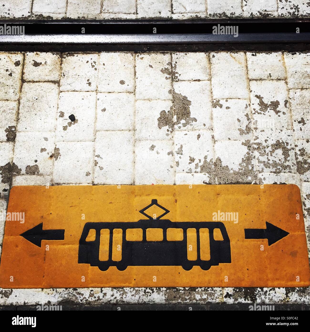 Symbole d'avertissement de tramway peint sur le sol à côté de pistes avec flèches directionnelles Banque D'Images