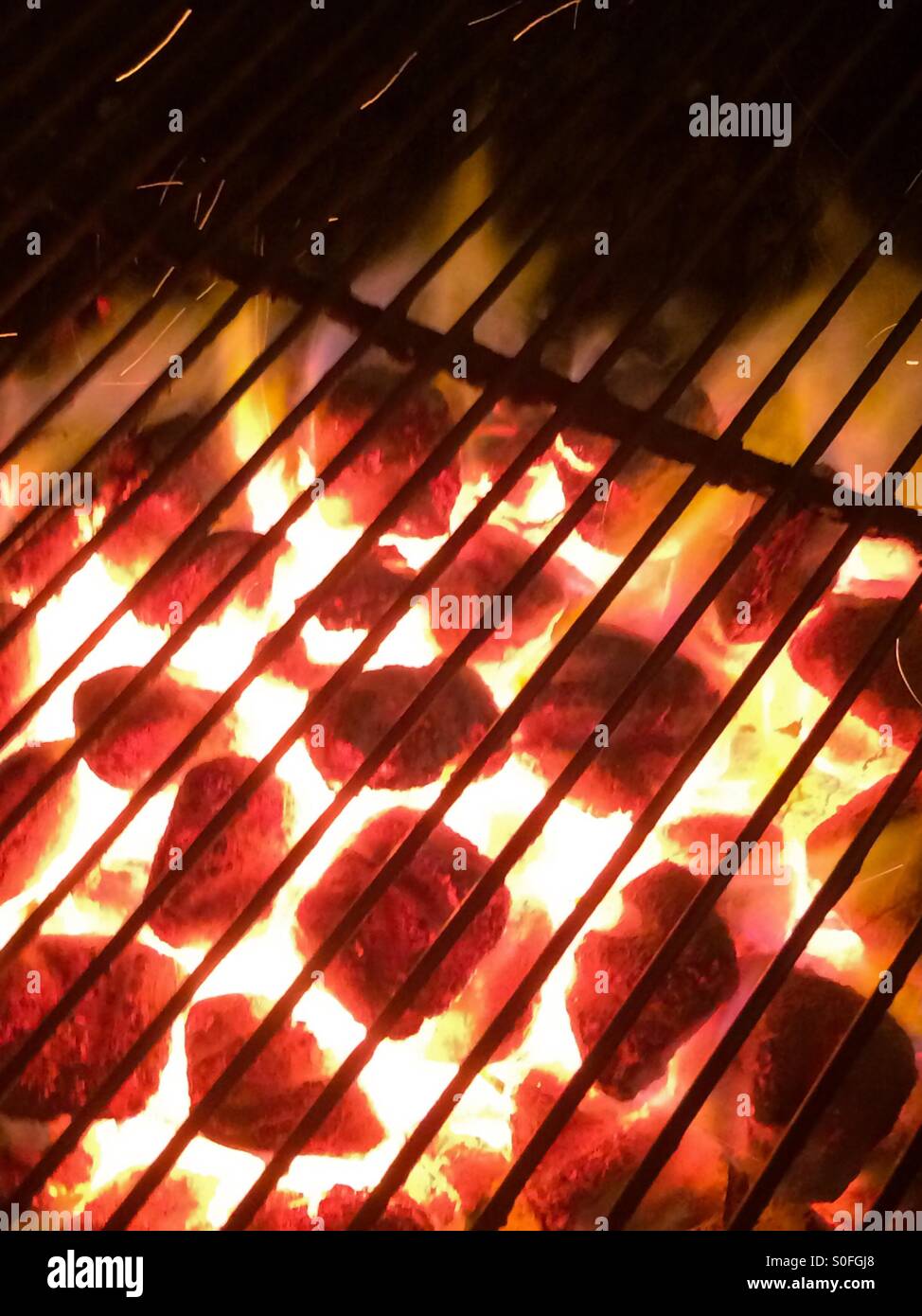 Chaud rougeoyant charbons dans un grill au charbon. - Image de stock capturée avec un smartphone