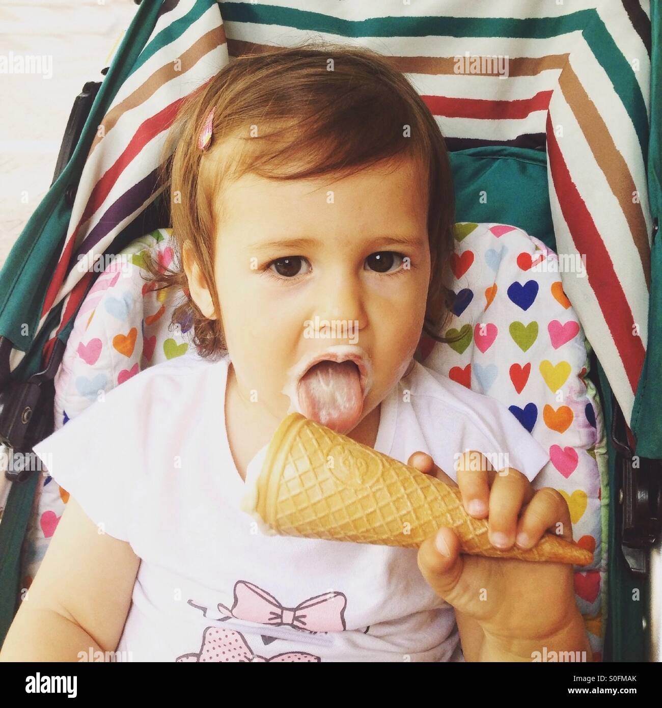 Cute little girl eating ice cream Banque D'Images