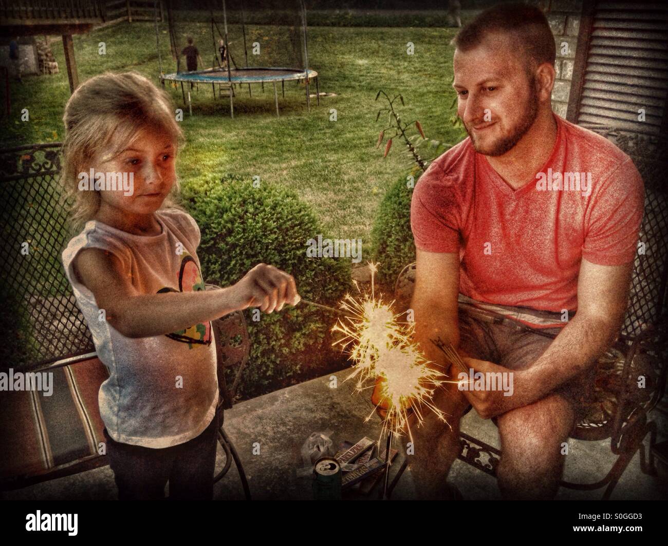 Un père et sa fille cierges lumière ensemble. Banque D'Images
