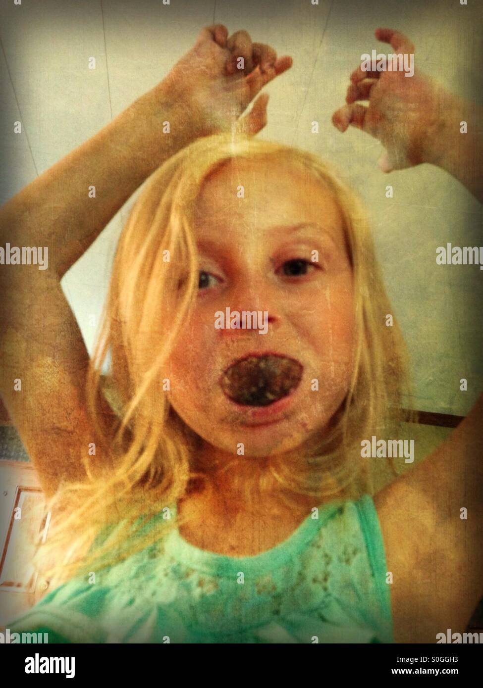 Une fille d'être ridicule avec un trou de beigne au chocolat dans sa bouche (2). Banque D'Images