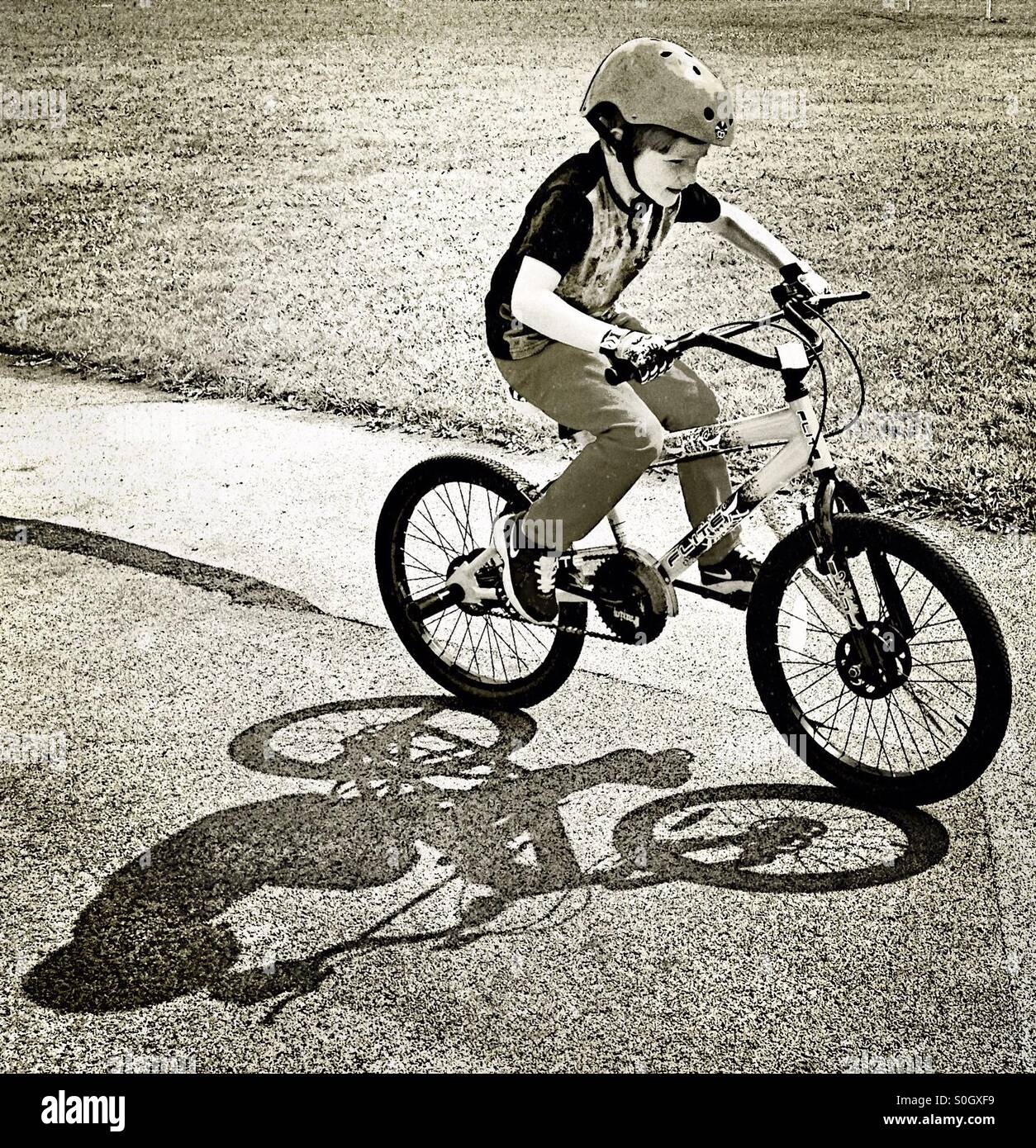 Boy riding bicycle son ombre- Banque D'Images