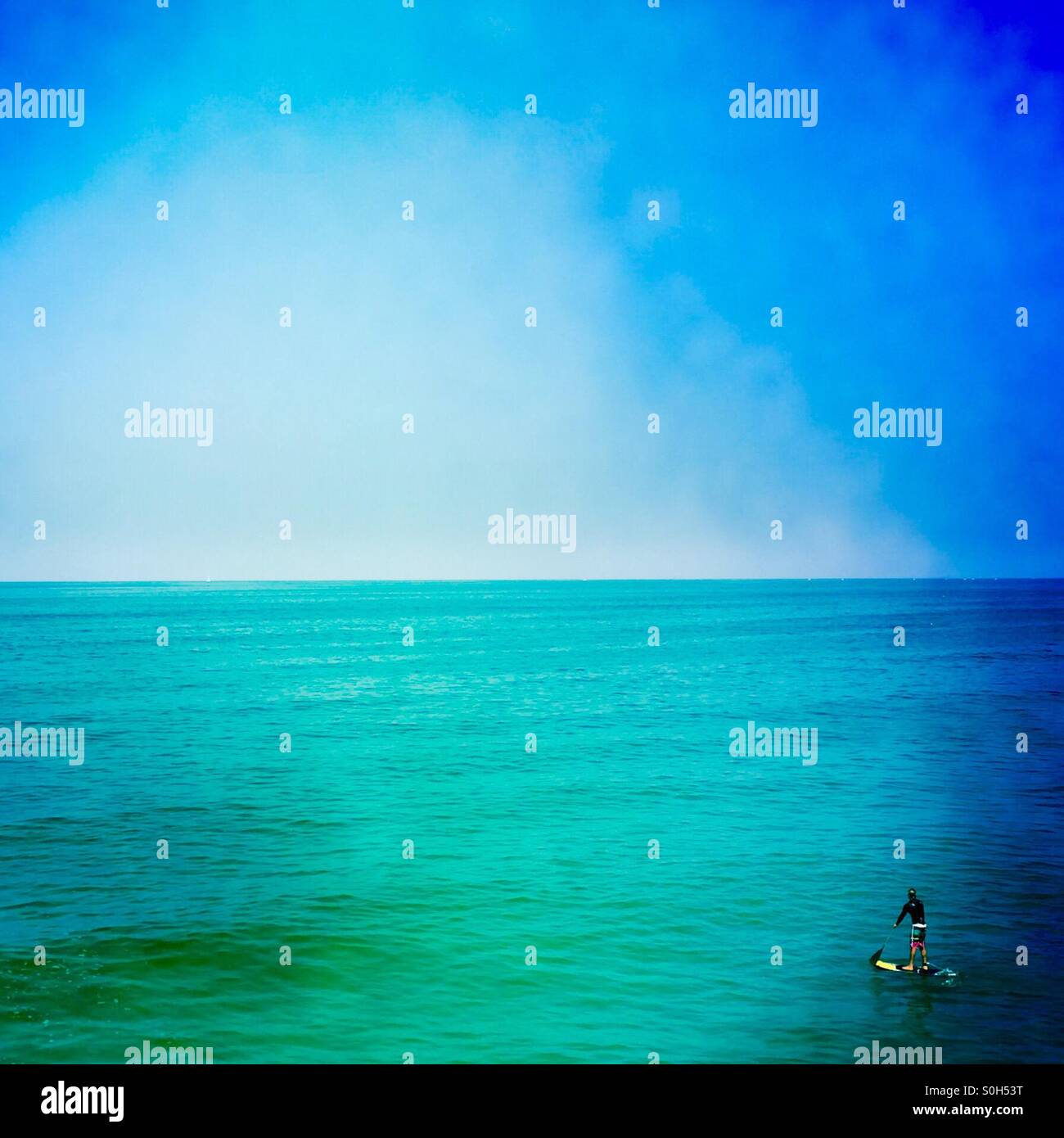 Un mâle stand up paddles surfeur. Manhattan Beach, Californie, États-Unis. - Image de stock capturée avec un smartphone