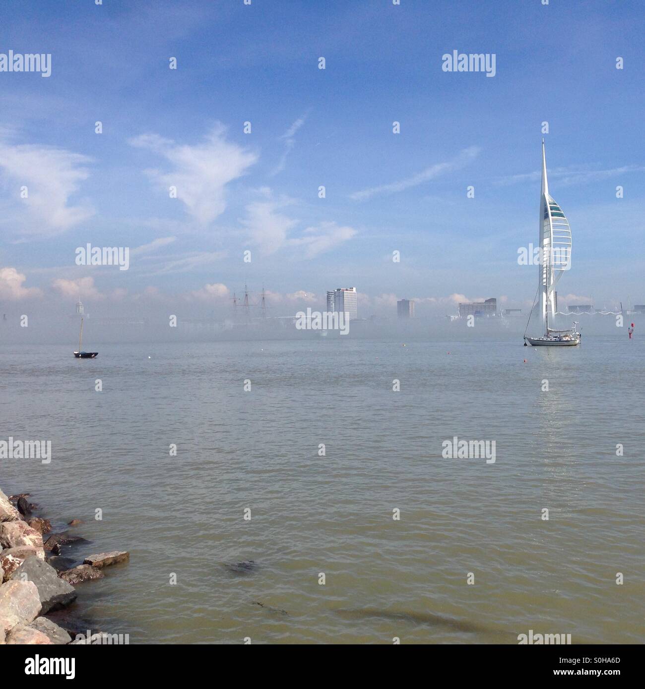 Gosport, Royaume-Uni. À la recherche sur le port de Portsmouth de Gosport côté avec la tour Spinnaker apparaissant de brouillard bas sur l'eau Banque D'Images