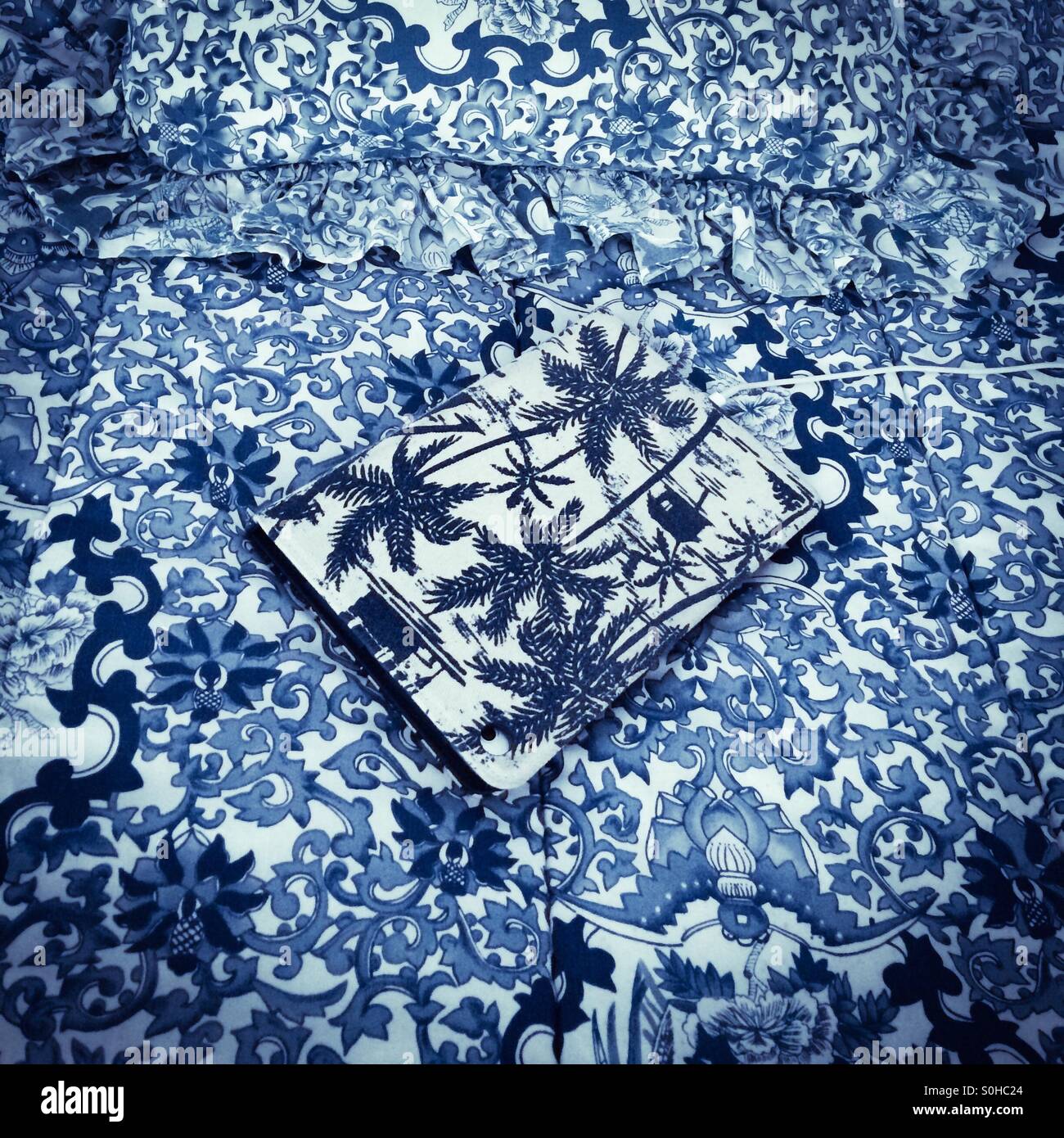 La recharge de l'iPad sur un camouflé couvre lit Banque D'Images