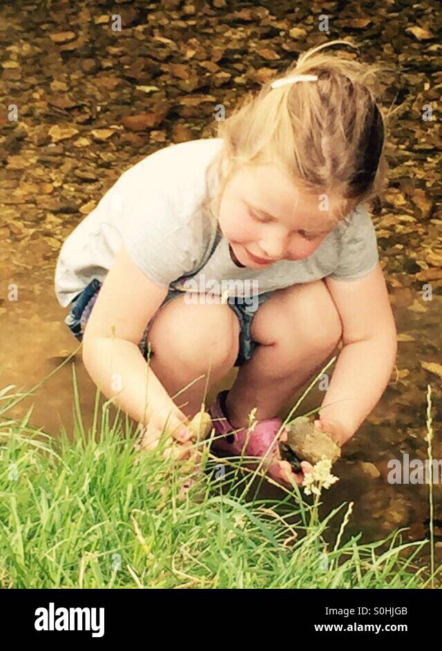 Petite fille jouant dans le ruisseau Banque D'Images