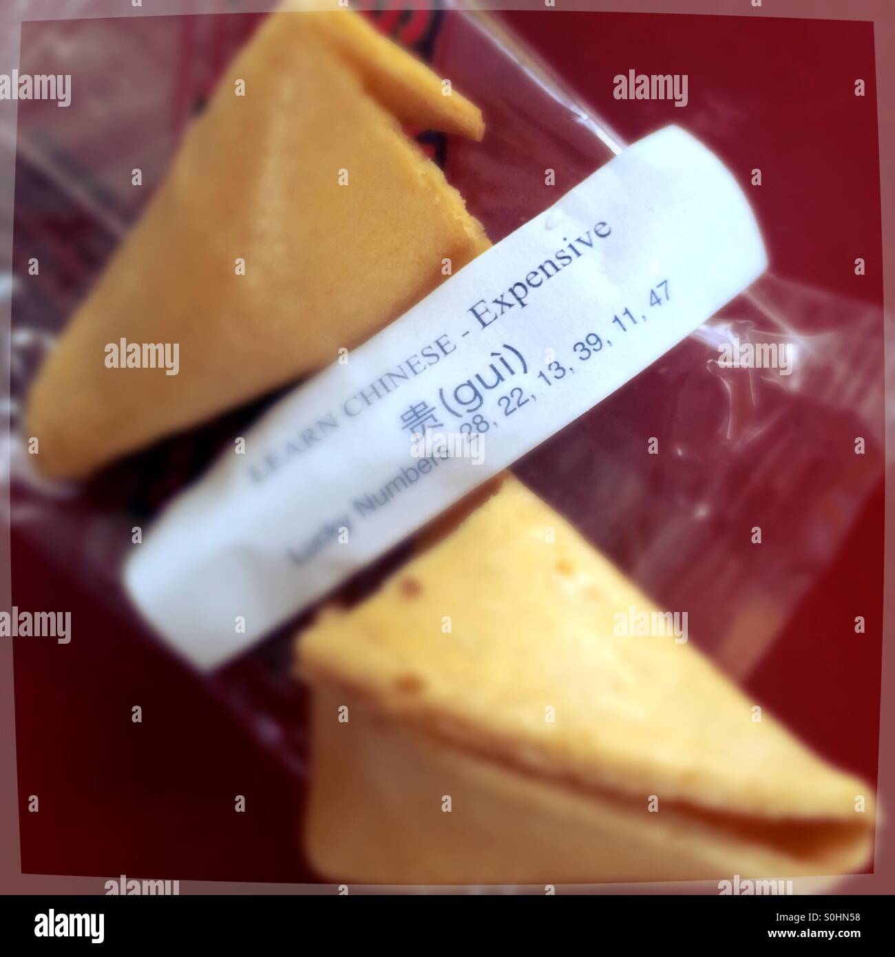 Ouverture d'un biscuit de fortune chinois enseigne des mots comme coûteux. - Image de stock capturée avec un smartphone