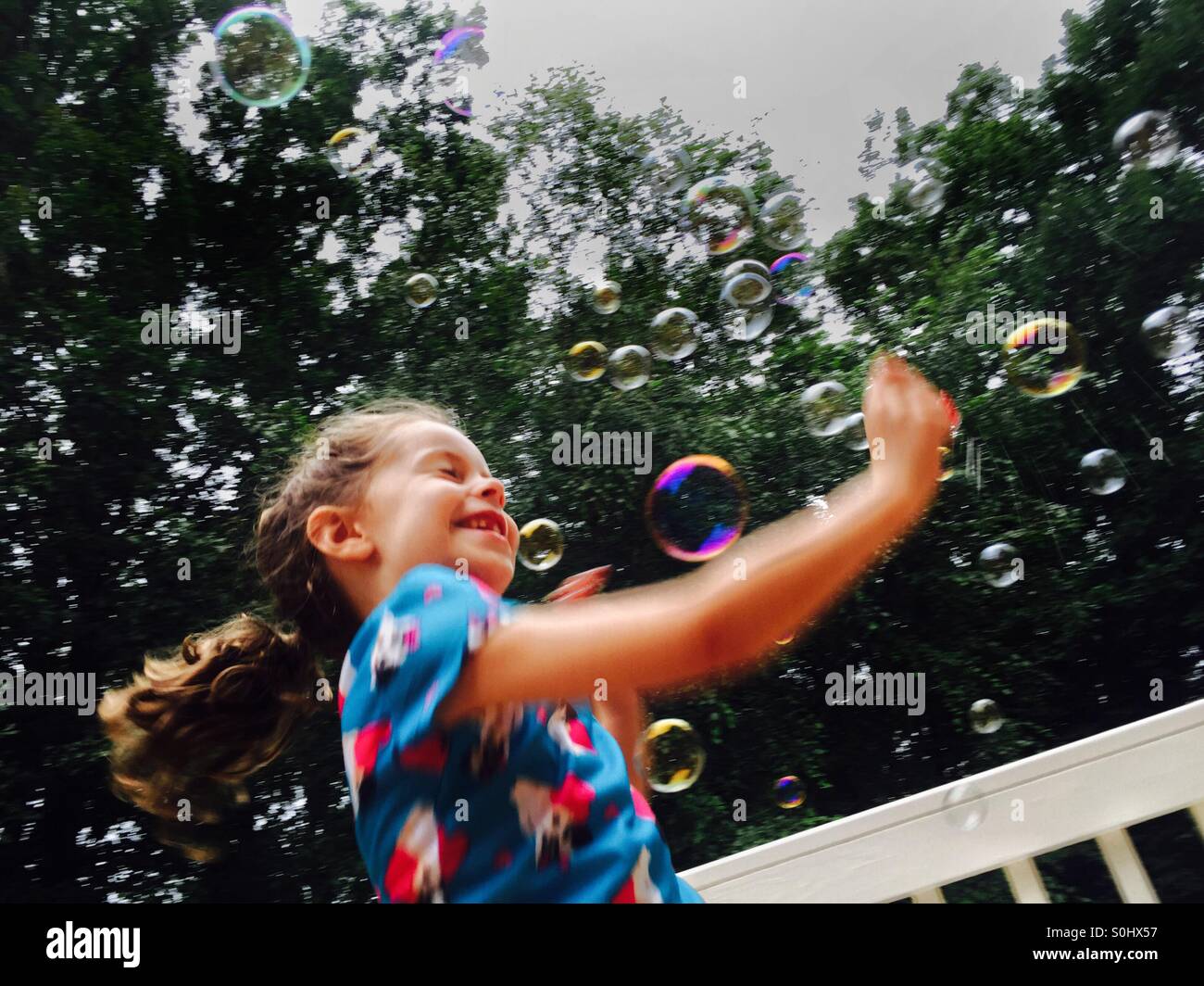 Petite fille jouant dans des bulles Banque D'Images