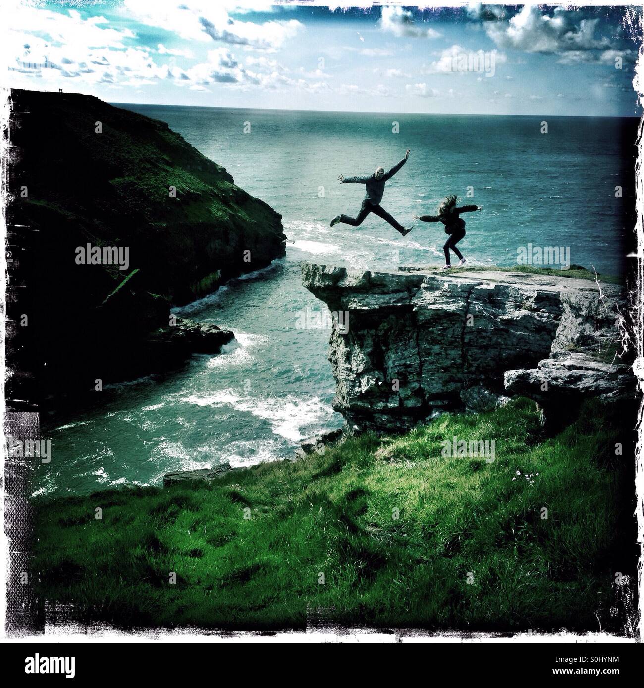 Les gens sautent en l'air tout en se posant pour une photographie sur le sentier du littoral, à Cornwall, en Angleterre. Banque D'Images