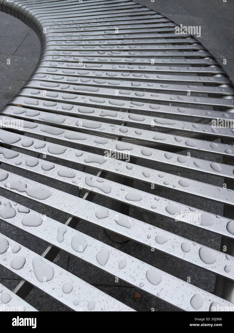 Les gouttelettes d'eau sur un banc en alliage à lattes - Image de stock capturée avec un smartphone